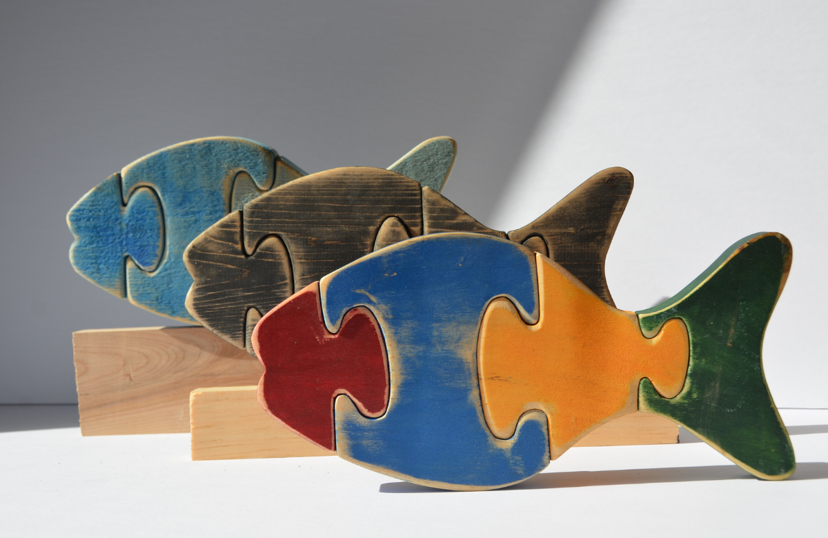 Three brightly coloured wooden fish puzzles