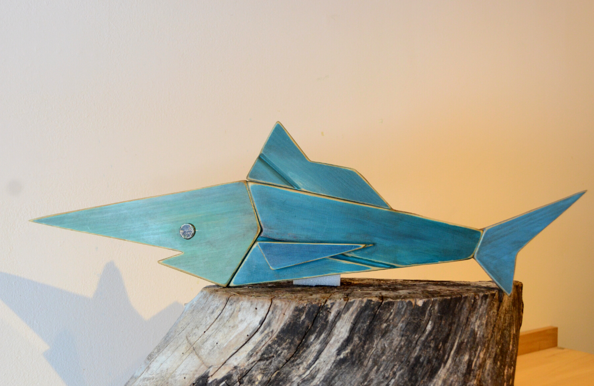 A long and narrow blue fish made of upcycled wood